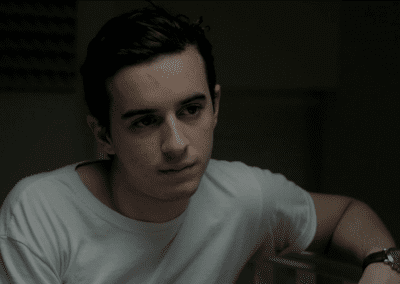 Young man sitting and leaning on a banister