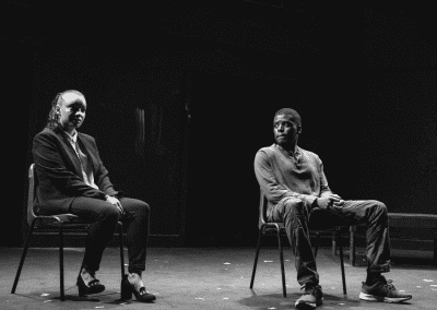 Man and woman sitting on stage in a theatre